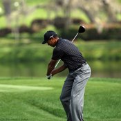 With his hips already rotating to his left, Tiger Woods brings the club forward during his downswing.