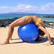 Stretching over an exercise ball loosens your spine, abdominal and shoulder muscles.