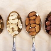 Spoons filled with different kinds of nuts.