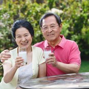A mature couple drinking a glass of milk.