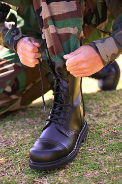 Soldier lacing up Army boot