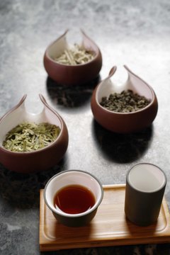 Jupiterimages/Goodshoot/Getty Images Green and black teas impact blood sugar in a variety of ways.