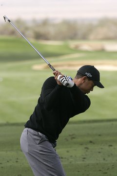 Tiger Woods' hands remain in front of his upper right chest near the top of his backswing.