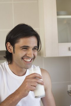 Jupiterimages/Comstock/Getty Images Vitamin D, a nutrient found in milk, promotes men's wellness in numerous ways.