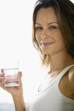 Creatas Images/Creatas/Getty Images Most women should drink about 9 cups of water a day.