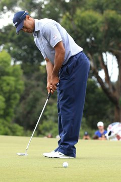 Tiger Woods displays his trademark putting grip at the 2011 Presidents Cup in Australia.
