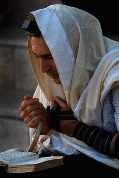 A religious Jew wearing both a tefillin and a tallit.