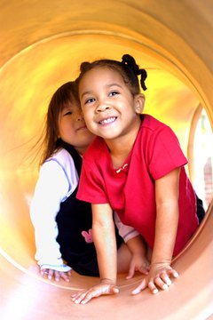 Climbing through a tunnel provides practice for spatial and body awareness.