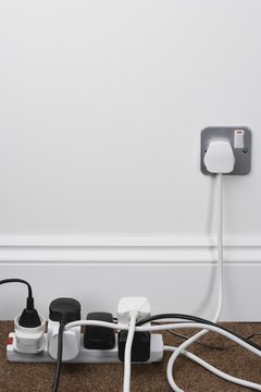 Jupiterimages/Polka Dot/Getty Images Hide electrical cords behind furniture or curtains, or elevate them to keep them out of your dog's mouth.
