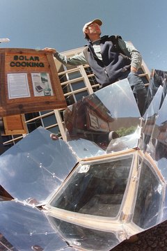 Michael Smith/Getty Images News/Getty Images Many solar cookers use reflectors to direct sunlight into the heating chamber.