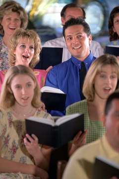 Brand X Pictures/Brand X Pictures/Getty Images Choir directors review and select songs to be performed.