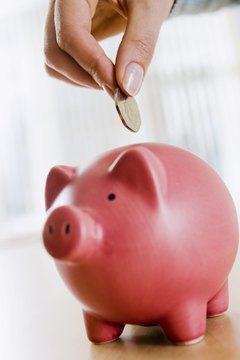 Hand with coin and piggybank