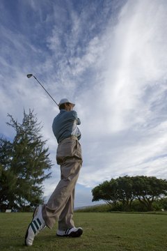 Professional golfers hone their swings during practice.