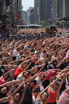 John Moore/Getty Images News/Getty Images Hundreds practice Bikram yoga in the hot summer temperatures in Times Square.