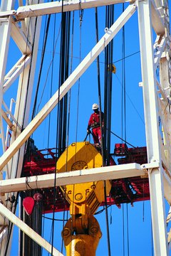 Photodisc/Photodisc/Getty Images Oilfield engineers often don a hard hat and supervise the work crew.