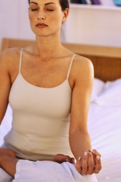 Stockbyte/Valueline/Getty Images Meditate in Lotus pose before you get up in the morning.