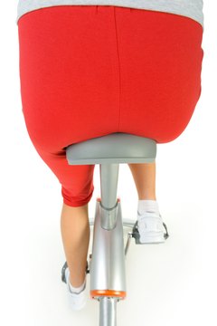 Jupiterimages/Photos.com/Getty Images To work the glutes cycling, stand up and push with your heels.