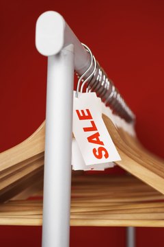 Rail of clothes hangers with sale tags attached, close-up
