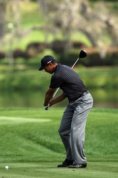 Tiger Woods allows his body and arms to lead the way during his downswing, keeping his hands passive as long as possible.