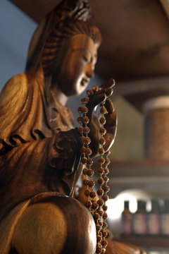 Followers may chant before a statue of a buddha.