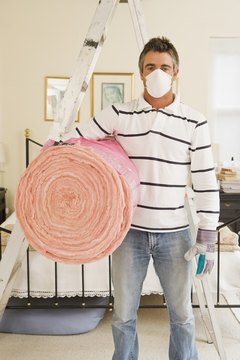 Jupiterimages/Pixland/Getty Images Always wear protective clothing and a face mask when working with fiberglass insulation.