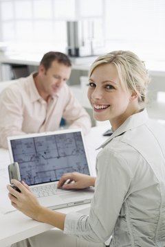 Smiling architect with laptop and cell phone