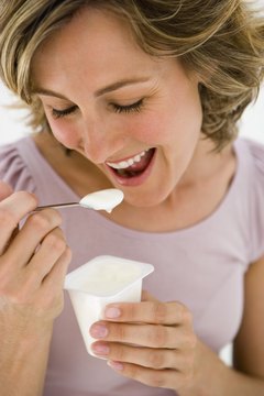 Jupiterimages/Pixland/Getty Images Snack on calcium-rich yogurt to improve bone health.