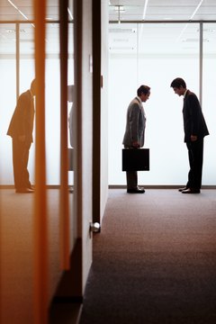 Businessmen in office hallway bowing to each other, side view