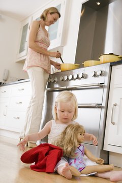 Toddlers develop manual dexterity by dressing and undressing their dolls.