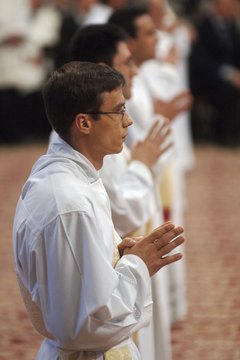 Catholic deacons, shown here praying in Vatican City, are servants of the bishop.