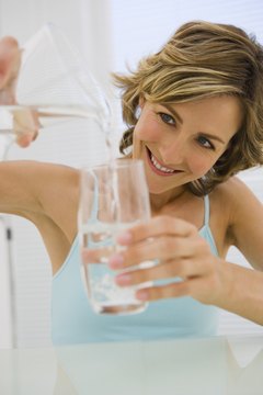 Jupiterimages/Pixland/Getty Images Drinking water during meals is not necessary for healthy digestion.
