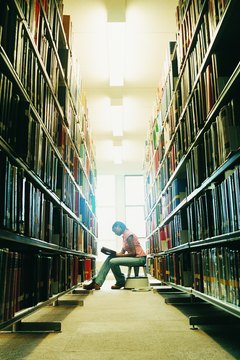 Female University Student Reading a Book in a Library