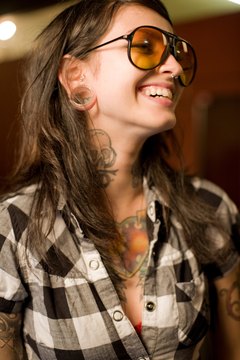 Jupiterimages/Photos.com/Getty Images A tattooed woman wears her ink as an accessory.
