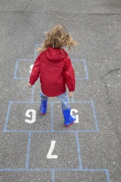 Little girl playing hopscotch