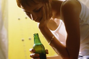 Woman looking at and holding beer bottle
