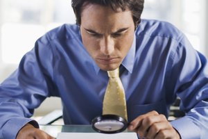 Businessman with magnifying glass reading small print