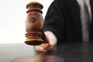 Close-up mid section of male judge banging gavel