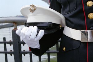 Gloved hand holding a Marine hat