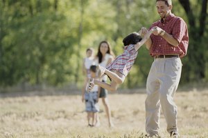 Father spinning his daughter outdoors