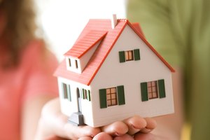 Couple holding miniature house