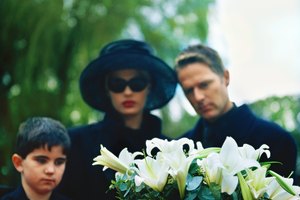 portrait of a young couple and their son standing over a coffin