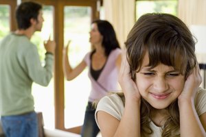 Girl covering ears while parents fight
