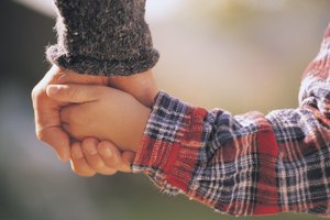 Child holding hands with adult