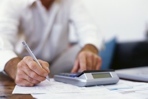 mid section view of a businessman using a calculator in an office