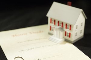 Model house next to paperwork and keys