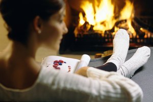 Woman reading magazine by fireplace