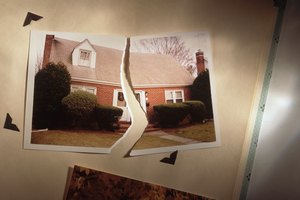 Torn photo of home symbolizes divorce
