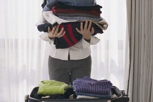 Woman putting clothes into suitcase