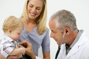 Mother holding baby so doctor can listen to chest with thermometer