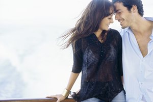 Young couple standing leaning against a railing of a boat